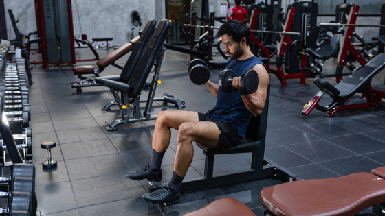 A man does bicep curls in a gym after taking a high-stim pre-workout